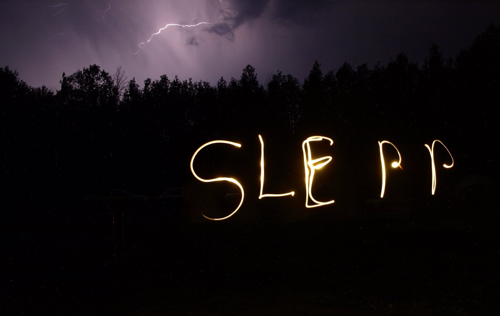 Long-exposure photograph spelling SLEPP in light beneath lightning